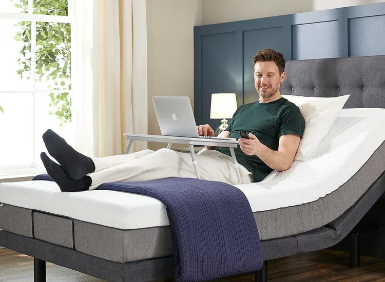 Person sleeping peacefully on an electric adjustable bed with head elevated in a calm neutral-toned bedroom
